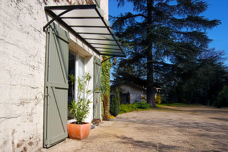 Marquise design en aluminium thermolaqué sur maison ancienne avec volets à Sarrebourg.