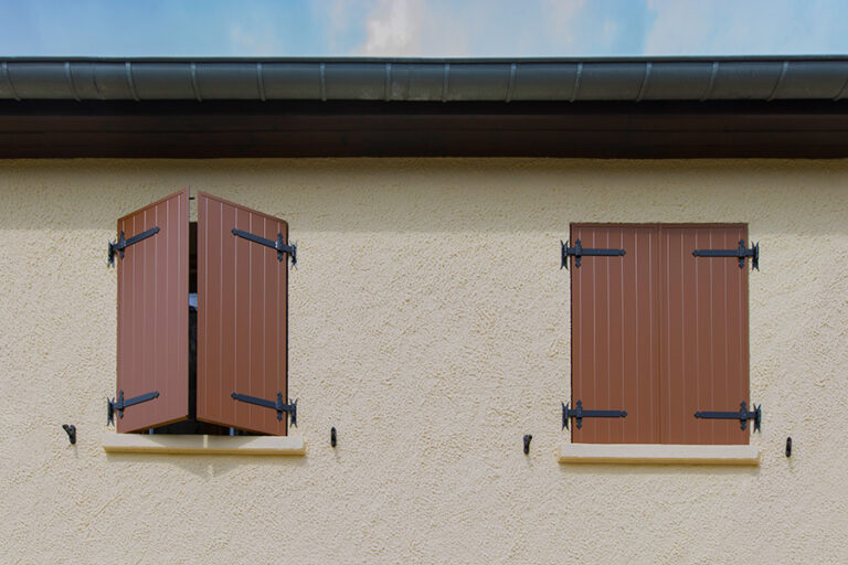 Maison en Moselle équipée de volets battants aluminium marron offrant sécurité et protection solaire